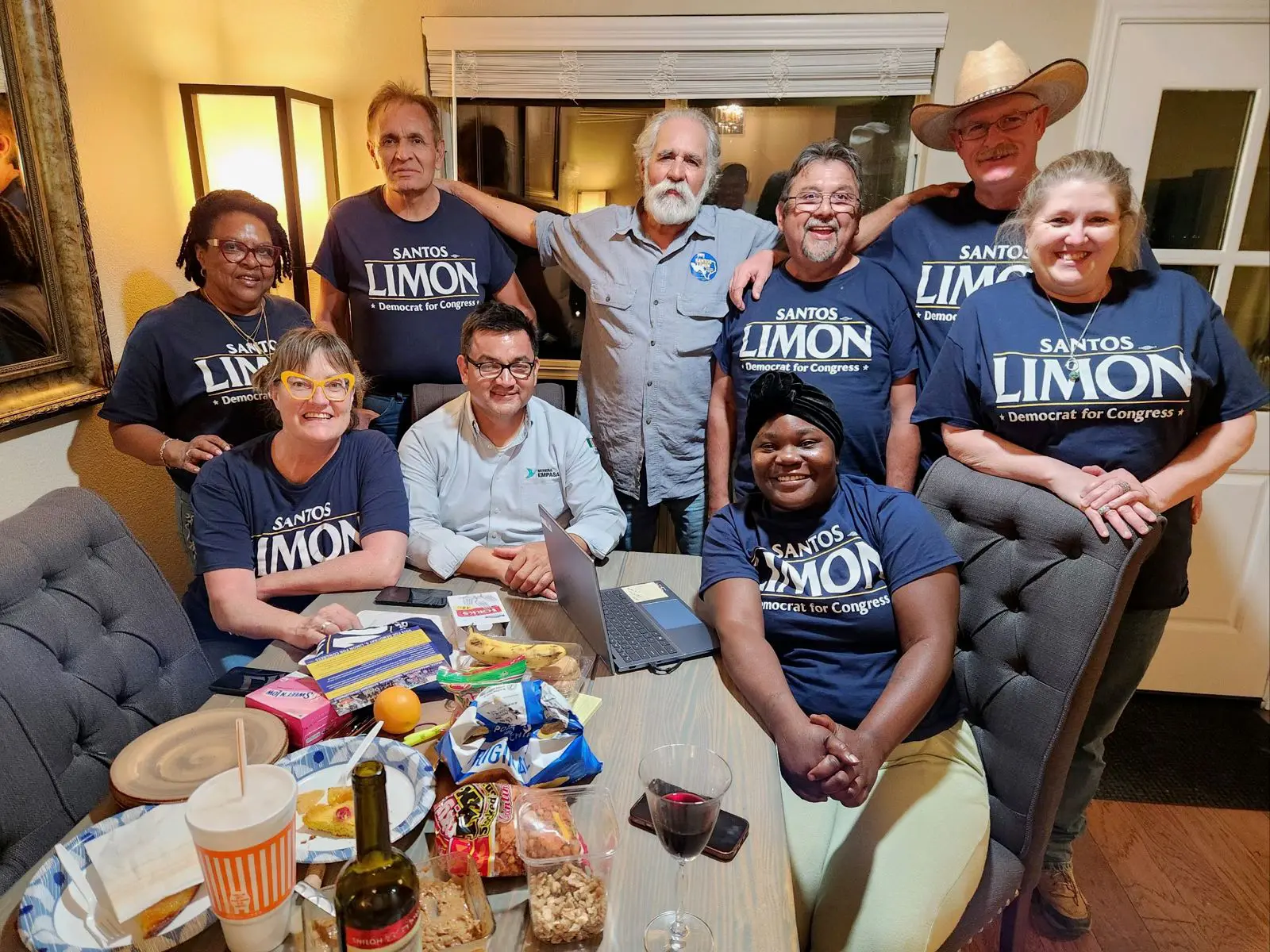 Group of smiling people gathered indoors, some wearing matching Limon shirts.